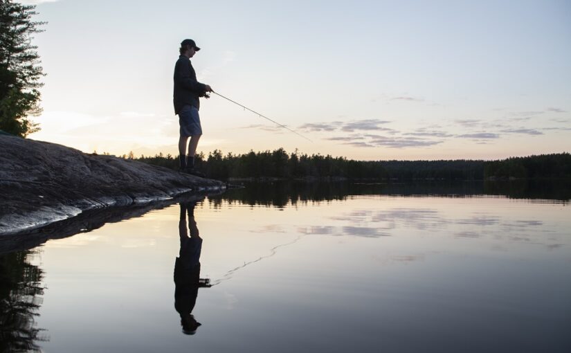 Homem pescando e reflexo na agua